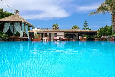 a large blue swimming pool next to a house at RUMAH SAYA in Campofelice di Roccella