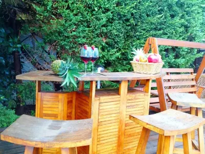 a wooden table with two chairs and two glasses of wine at RUMAH SAYA in Campofelice di Roccella