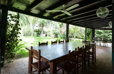 a large wooden table with chairs and a ceiling fan at RUMAH SAYA in Campofelice di Roccella