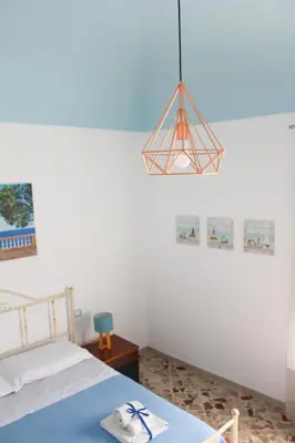 a bedroom with a bed and a chandelier at Narciso Blu in Castellammare del Golfo