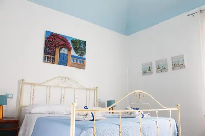 a bedroom with a bed and a painting on the wall at Narciso Blu in Castellammare del Golfo