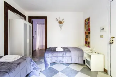 a bedroom with two beds and a tiled floor at Amunì in Palermo