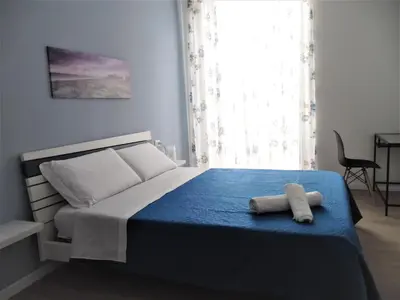 a bedroom with a bed with a blue blanket at Le vie del Centro in Palermo