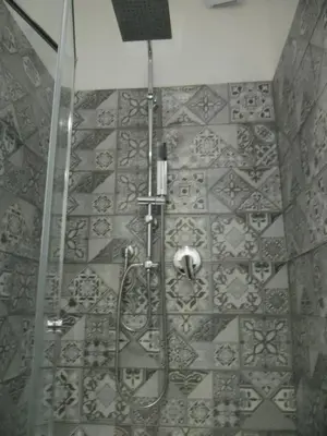 a shower in a bathroom with a tile wall at Le vie del Centro in Palermo
