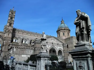 a statue in front of a building with a cathedral at Le vie del Centro in Palermo