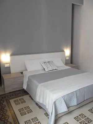 a bedroom with a large bed with white sheets at Le vie del Centro in Palermo