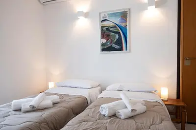 two beds in a room with white towels on them at Casa Azzurra sul mare e centralissima in San Vito lo Capo
