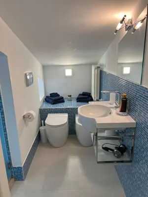 a bathroom with a sink and a toilet and a mirror at Duchessa House in Castellammare del Golfo
