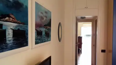a hallway with paintings hanging on a wall at Suites Mondello Deluxe in Mondello