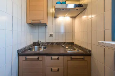 a small kitchen with a sink and a stove at The Normans Apartments in Palermo