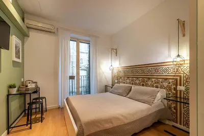a bedroom with a bed and a desk and a window at Casa Abbanniata a Ballaro' by Wonderful Italy in Palermo