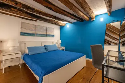a bedroom with a blue accent wall and a bed at Casa Abbanniata a Ballaro' by Wonderful Italy in Palermo