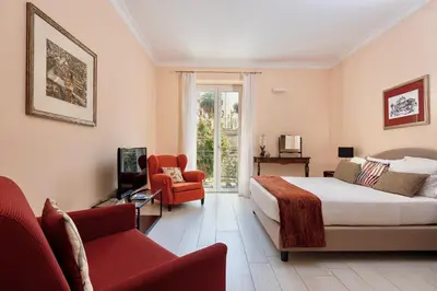 a bedroom with a bed and a couch and a chair at I Mori di Porta Nuova Suite & Terrace in Palermo