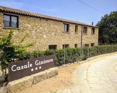 a stone building with a sign in front of it at Casale Ginisara in Castellammare del Golfo