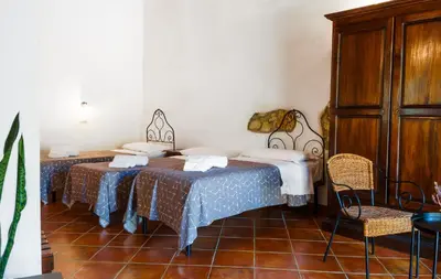 a room with two beds and a cabinet at Casale Ginisara in Castellammare del Golfo