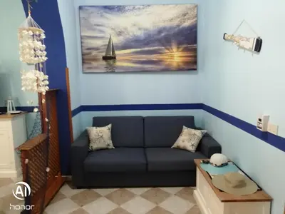 a living room with a couch and a sailboat on the wall at Casa 