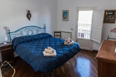 a bedroom with a blue bed with towels on it at Appartamento Palazzo Pace al Cassaro in Palermo