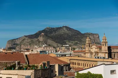a view of a city with a mountain in the background at Appartamento Palazzo Pace al Cassaro in Palermo