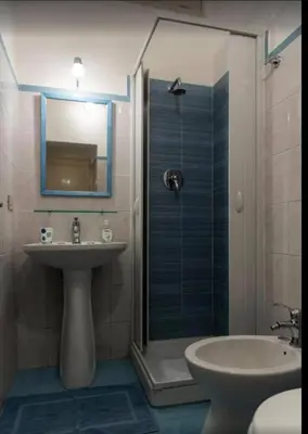 a bathroom with a sink and a shower with a mirror at Appartamento Palazzo Pace al Cassaro in Palermo