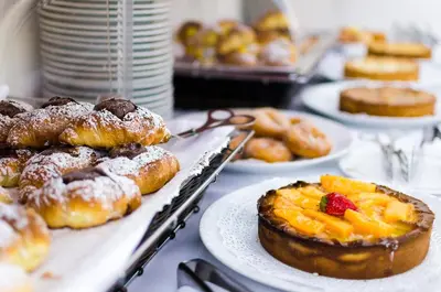 a table topped with plates of pastries and other desserts at Hotel Garibaldi in Palermo