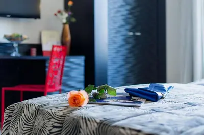 a flower on a bed with a tray of food at Hotel Garibaldi in Palermo