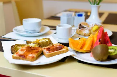 two plates of food on a table with fruit at Hotel Garibaldi in Palermo