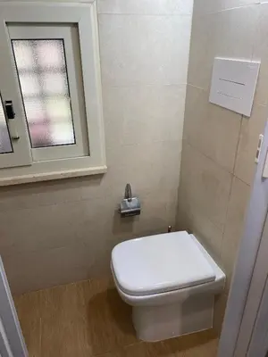 a bathroom with a white toilet and a window at Tiny House Basilio in Palermo