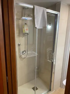 a shower with a glass door in a bathroom at Tiny House Basilio in Palermo