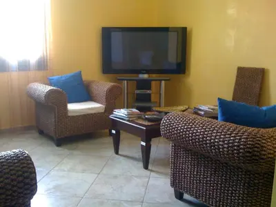 a living room with chairs and a flat screen tv at Hotel Altamarea in San Vito lo Capo