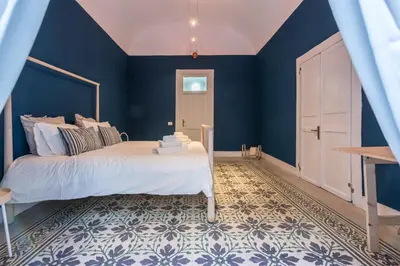 a bedroom with blue walls and a large bed at Qasr Home Beautiful apartment in Palermo in Palermo