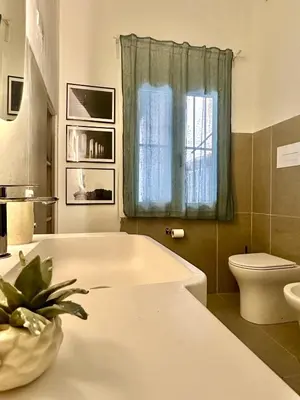 a bathroom with a tub and a toilet and a window at Qasr Home Beautiful apartment in Palermo in Palermo