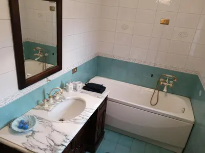 a bathroom with a sink and a tub and a mirror at A casa di Zara in Termini Imerese