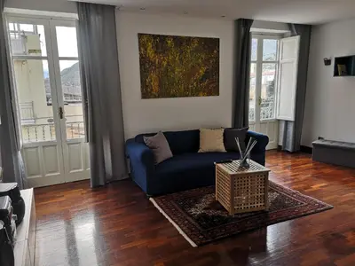 a living room with a blue couch and a painting at A casa di Zara in Termini Imerese