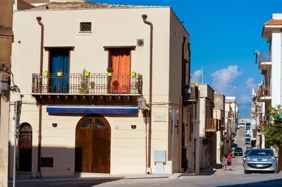 a building on a street with a balcony at Camere Simona in Castellammare del Golfo