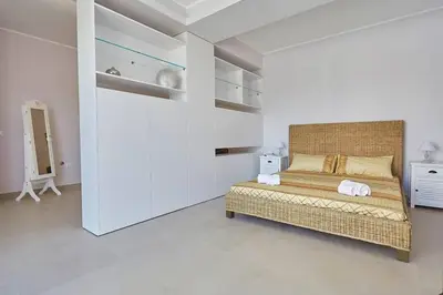 a bedroom with a large bed in a white room at Villa Biancolilla in Castellammare del Golfo