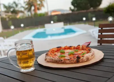 a pizza sitting on a table with a glass of beer at RESORT Valle del Re in Partinico