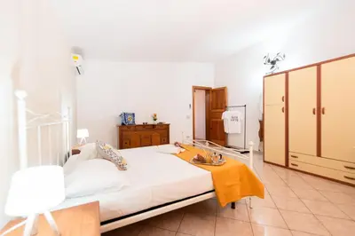 a bedroom with a bed and a dressing room at Villa Minoa con piscina in San Vito lo Capo