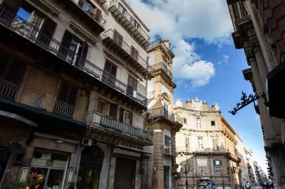 a building with balconies on the side of a street at GuestHost - Quattro Canti Charming Flat in Palermo