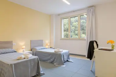 a room with two beds and a window at Casa per Ferie Don Orione Palermo in Palermo