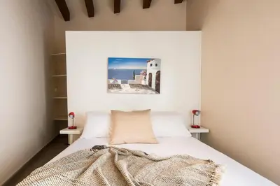a bedroom with a bed with a picture on the wall at Santa Cecilia Apartment by Wonderful Italy in Palermo