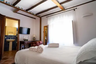 a bedroom with a large white bed with towels on it at Villa Vittoria Hotel in Alcamo