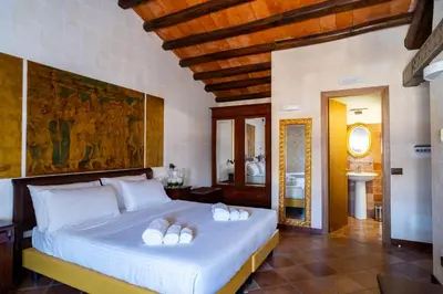 a bedroom with a large bed with white pillows at Villa Vittoria Hotel in Alcamo