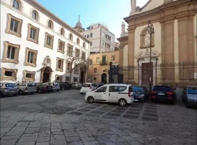 a white car parked in a parking lot next to a building at Loft CASA PROFESSA 1 in Palermo