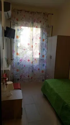a bedroom with a bed and a window with a curtain at La Casita 24 in Palermo