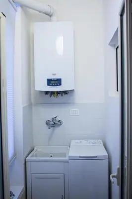 a white kitchen with a sink and a white cabinet at La Casita 24 in Palermo