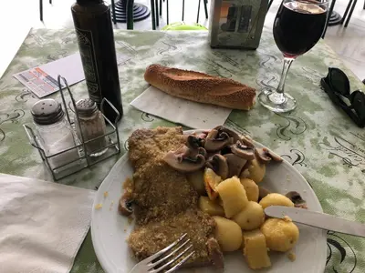 a plate of food on a table with a glass of wine at ALBA DEL CAPO in Palermo
