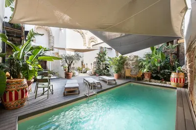 an indoor pool with plants and a large umbrella at Porta di Castro Hotel & SPA in Palermo