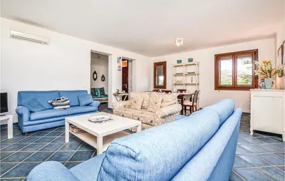 a living room with blue couches and a table at Villa Joly in Terrasini
