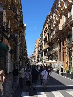 a group of people walking down a city street at Casa Santa Sofia in Palermo