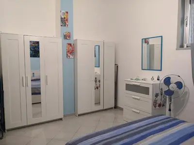a bedroom with white cabinets and a bed and a sink at Short Lets Vacanze 